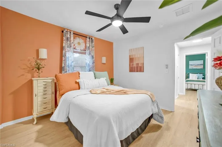 Bedroom with light wood-style floors, ceiling fan, and baseboards