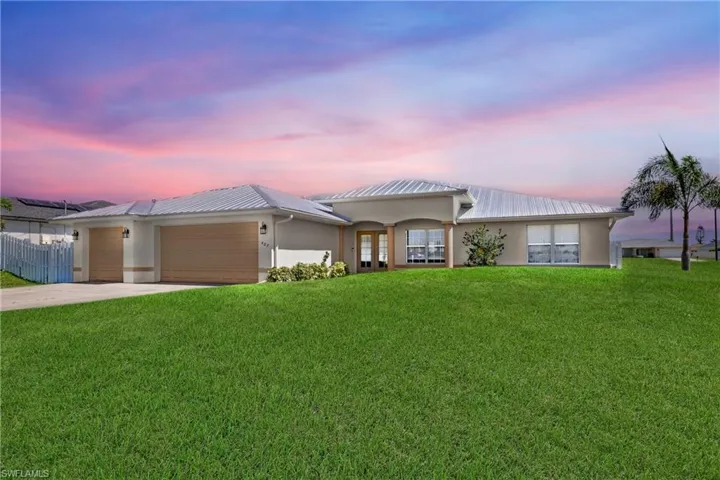 Single story home featuring a garage and a yard