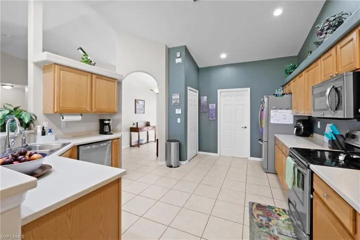 Kitchen featuring light brown cabinets, sink, light tile flooring, and stainless steel appliances