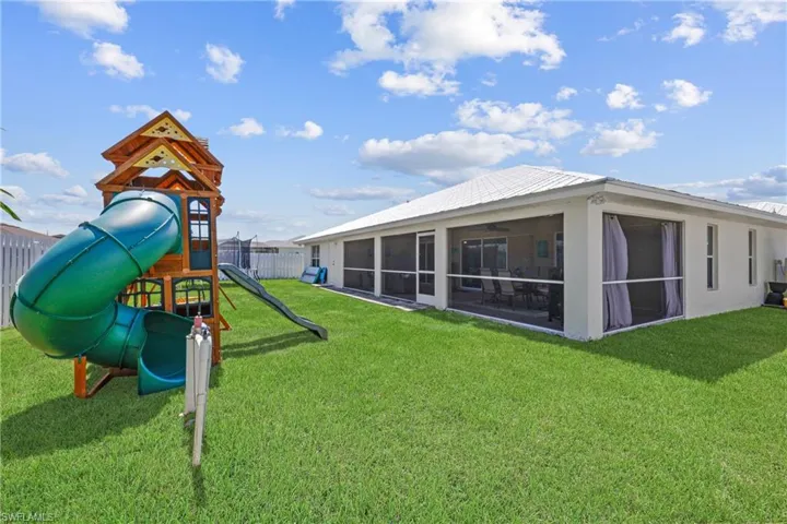 View of play area with a sunroom and a yard