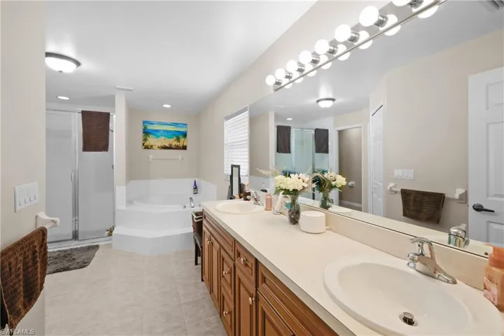 Bathroom with tile flooring, dual vanity, and independent shower and bath