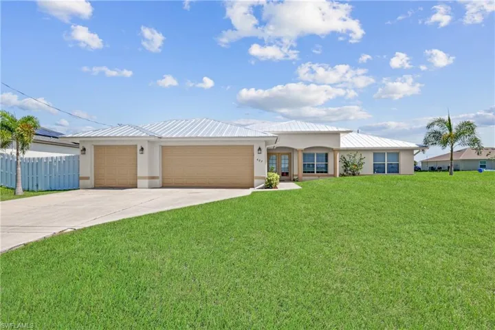 Ranch-style house with a garage and a front lawn
