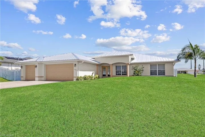 Ranch-style house with a garage and a front lawn