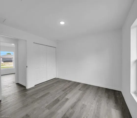 Unfurnished bedroom featuring a closet, light wood-style floors, and recessed lighting