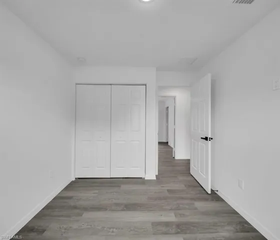 Unfurnished bedroom featuring wood finished floors and a closet