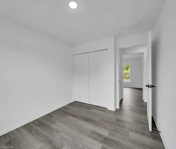 Unfurnished bedroom featuring a closet and wood finished floors