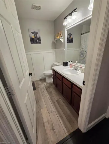 Bathroom featuring vanity, hardwood / wood-style floors, toilet, and a shower with shower curtain