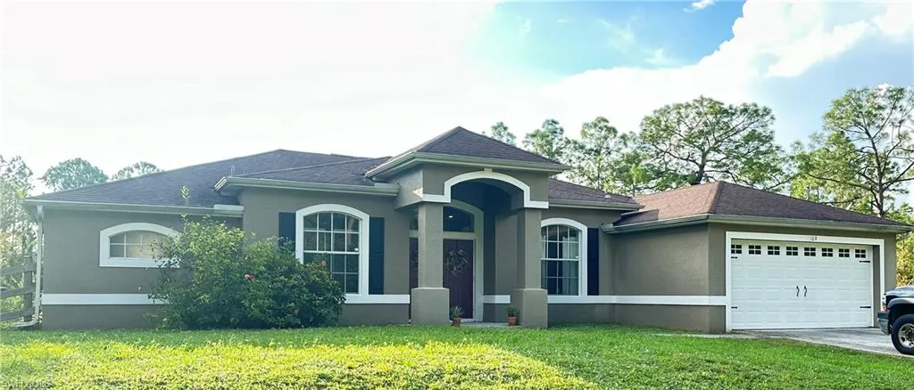 View of front of home with a front lawn and a garage