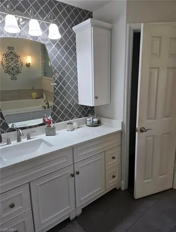 Bathroom featuring tile patterned floors, a tub, and vanity