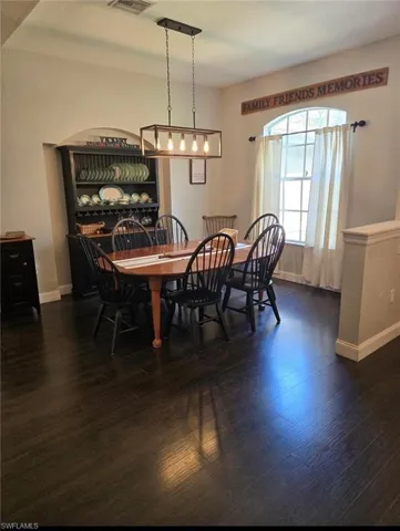 Dining room with dark hardwood / wood-style flooring