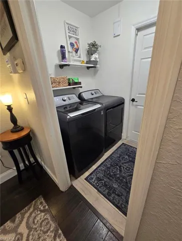 Washroom featuring separate washer and dryer and dark hardwood / wood-style floors