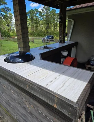 Wooden deck featuring a lawn and sink
