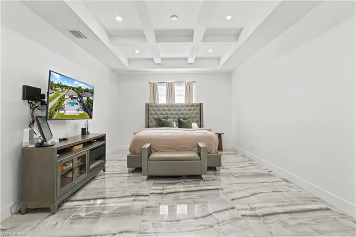 Bedroom with beamed ceiling, coffered ceiling, light marble finish floors, and recessed lighting