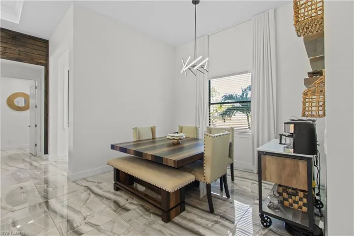 Dining space featuring light marble finish flooring and a chandelier