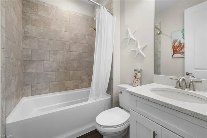 Bathroom featuring vanity and shower / tub combo with curtain