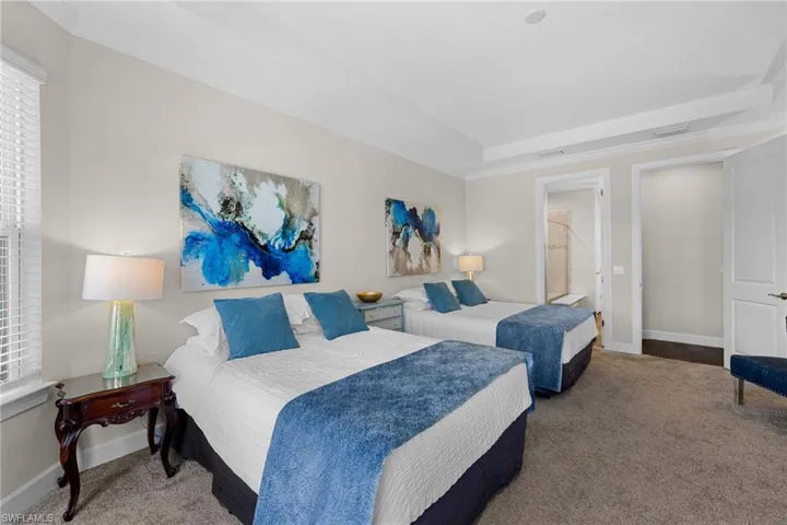Bedroom featuring carpet flooring, crown molding, a raised ceiling, and ensuite bathroom
