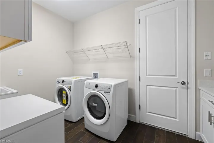 Laundry area featuring cabinet space, wood finish floors, and washing machine and dryer