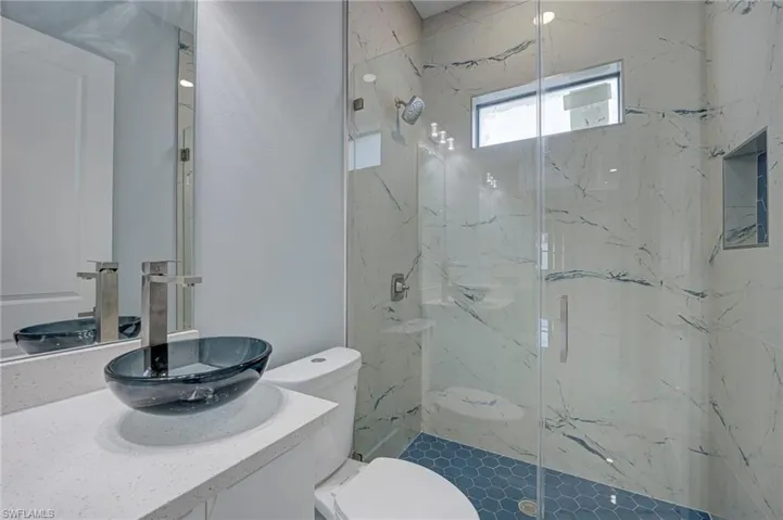 Full bath with vanity and a marble finish shower