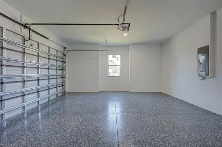 Garage featuring electric panel and a garage door opener