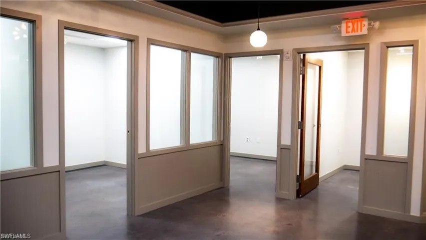 Hall featuring baseboards and concrete floors