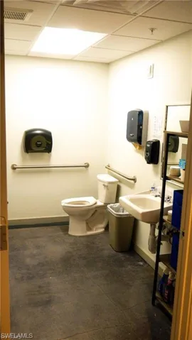 Private Bathroom with visible vents, baseboards, a sink, a paneled ceiling, and toilet