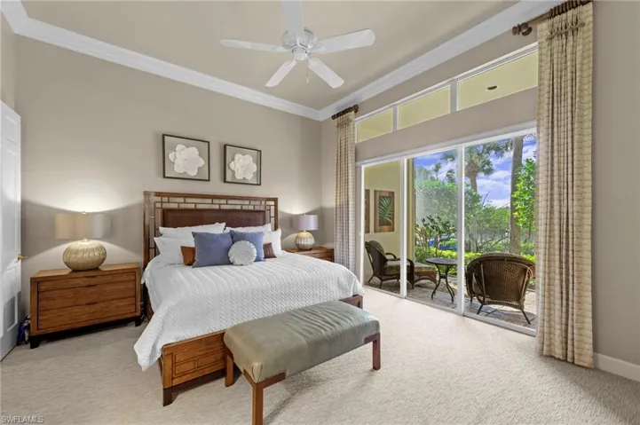Carpeted bedroom featuring ornamental molding, access to exterior, and a ceiling fan