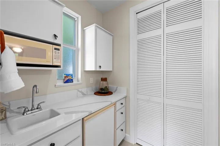 Guest Cabana Kitchenette featuring white cabinetry, white microwave, and light counters