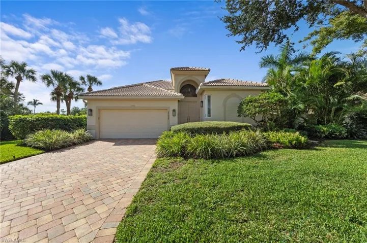 Mediterranean / spanish home featuring an attached garage, decorative driveway, stucco siding, a front yard, and a tiled roof