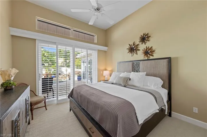 Guest bedroom with light colored carpet, a ceiling fan, and access to exterior