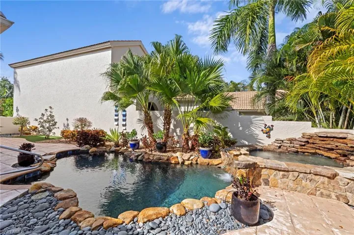 Outdoor pool with a waterfall from hot tub