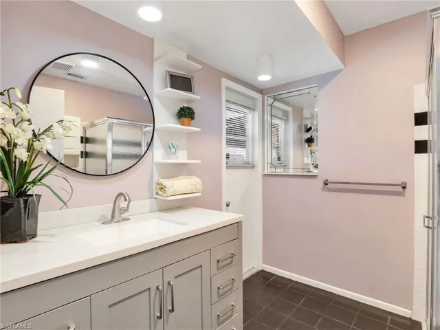 Full bathroom featuring a stall shower and pool access.