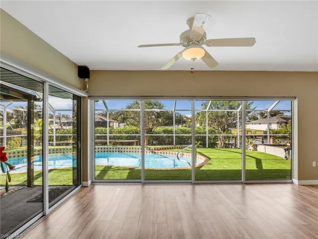Unfurnished sunroom featuring ceiling fan