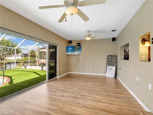 Unfurnished room with a ceiling fan, light wood-style floors, and baseboards