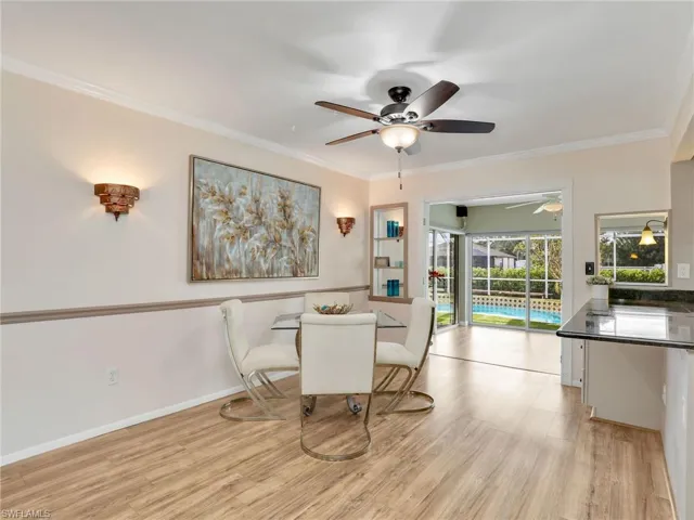 Dining room with a ceiling fan, inished floors, and crown molding