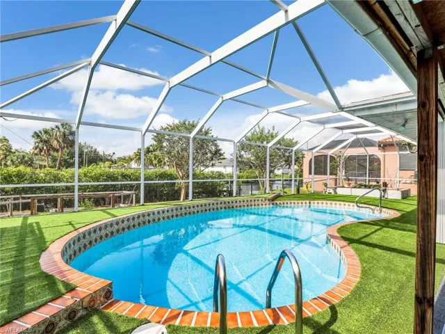 Swimming pool with a lawn and glass enclosure