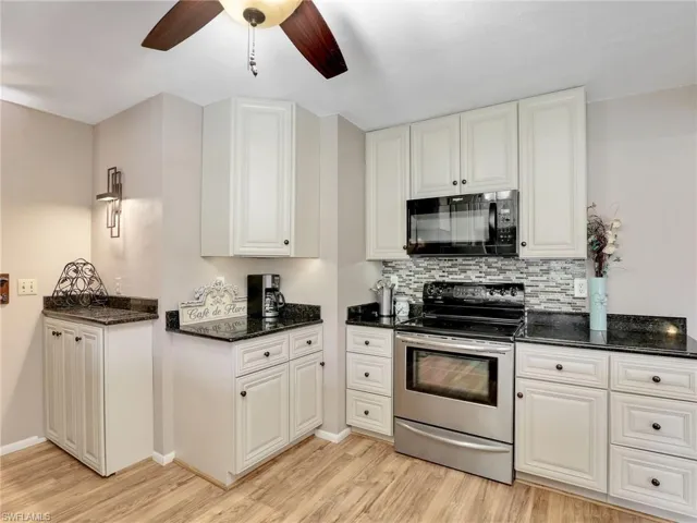Kitchen with stainless steel electric range, ceiling fans