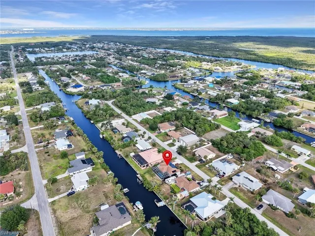 Aerial overview of property's location with a nearby body of water and nearby suburban area