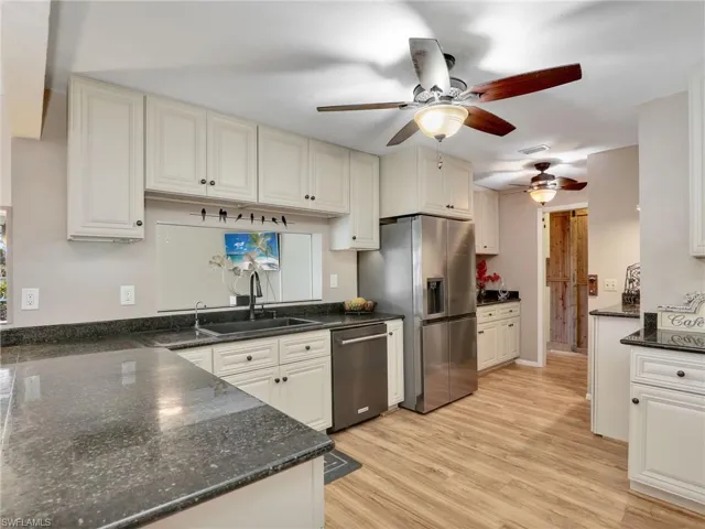 Kitchen with stainless steel appliances, ceiling fan, light and granite counters, plenty of cabinets for storage