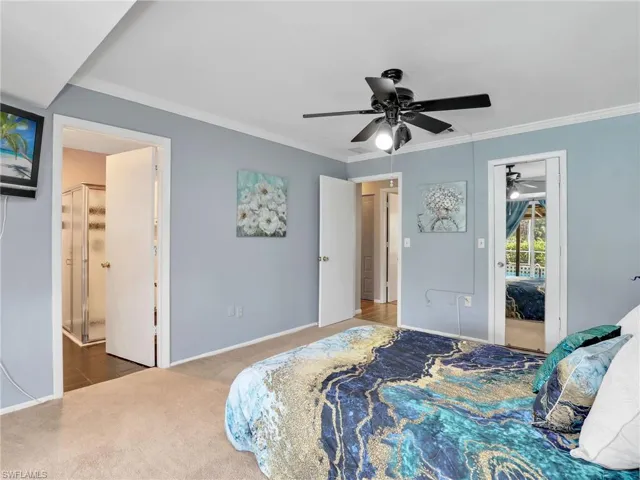Carpeted bedroom featuring baseboards, crown molding, and ceiling fan
