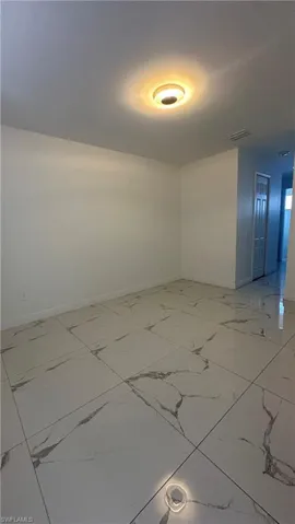 Unfurnished room featuring baseboards and light marble finish floors