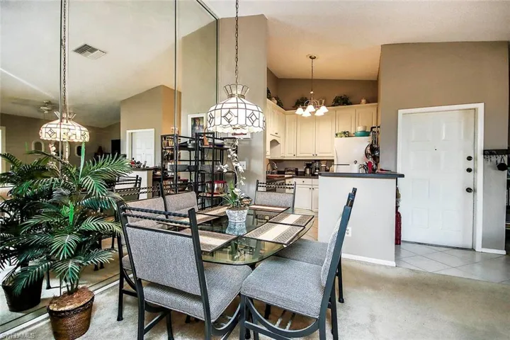 Tiled dining space with high vaulted ceiling and a chandelier