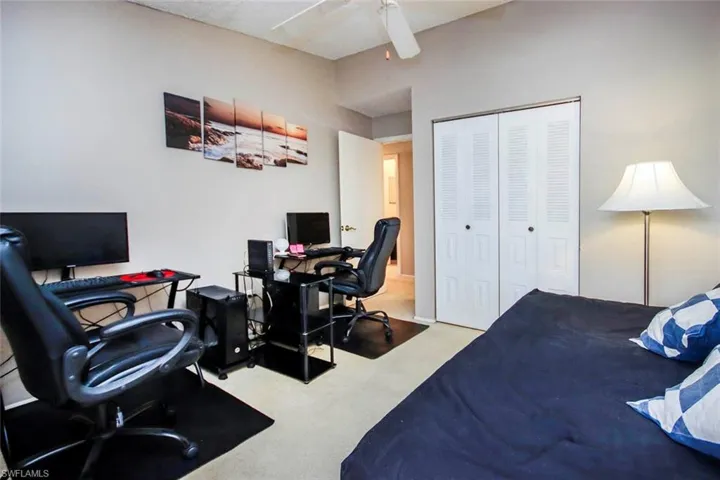 Carpeted bedroom featuring a closet and ceiling fan
