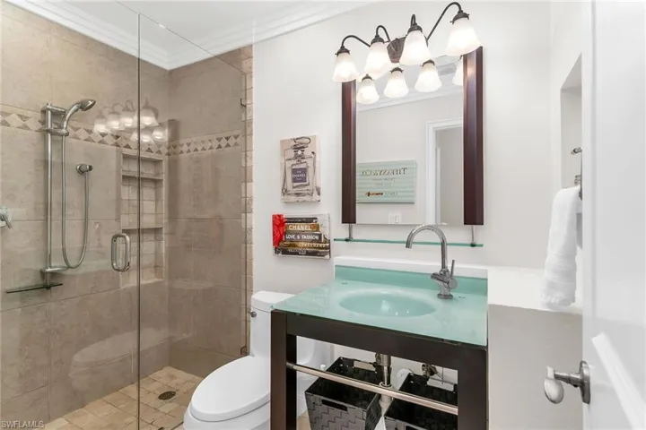 Bathroom with crown molding and a stall shower