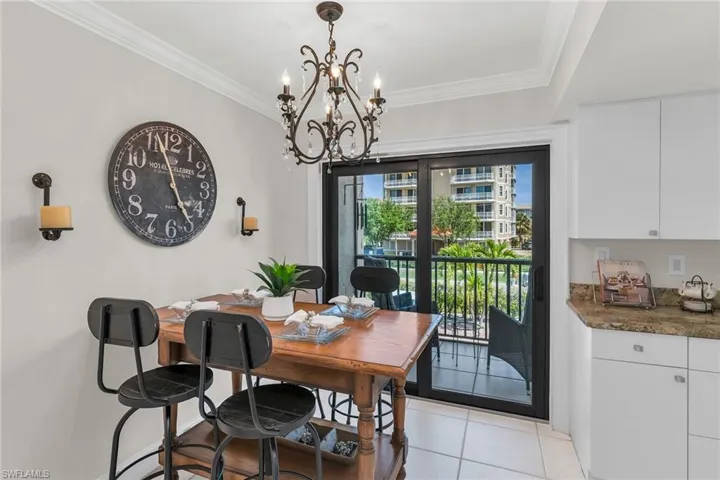 Dining space featuring ornamental molding, a chandelier, and light tile patterned flooring