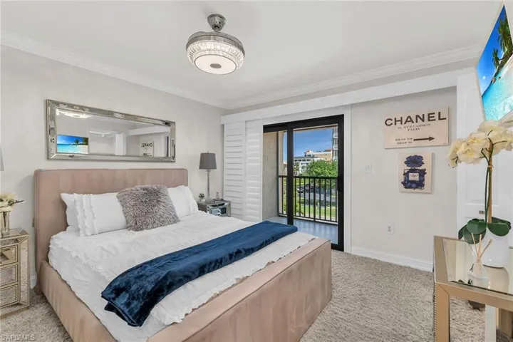 Bedroom with crown molding, light carpet, and access to outside