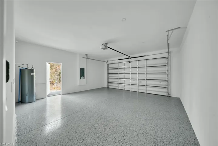 Garage featuring water heater and electric panel