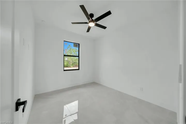 Empty room with ceiling fan and baseboards