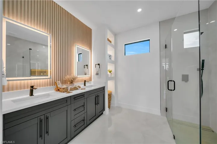 Full bathroom with double vanity, a stall shower, and recessed lighting