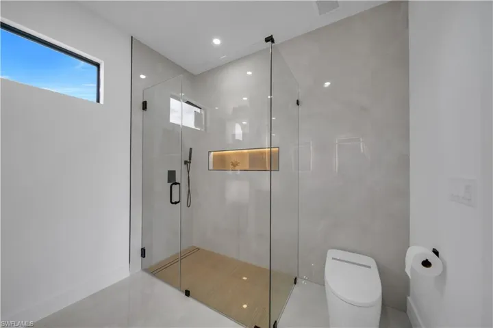 Bathroom with a shower stall and recessed lighting