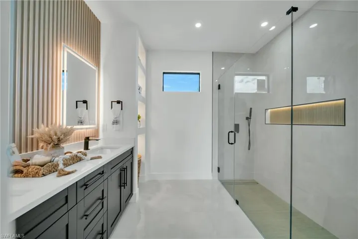 Bathroom with double vanity, a stall shower, and recessed lighting